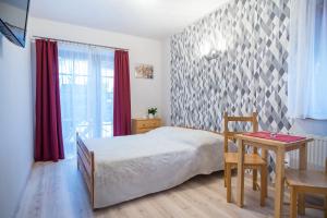 - une chambre avec un lit, une table et une fenêtre dans l'établissement Willa 4 Pory Roku, à Kazimierz Dolny