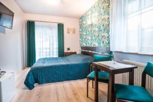 a bedroom with a bed and a table and chairs at Willa 4 Pory Roku in Kazimierz Dolny