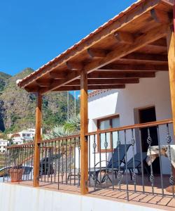 a deck with a wooden pergola and chairs at Casa La Sabina Roja 1 - Casa con impresionantes vistas sobre Hermigua y el mar in Hermigua