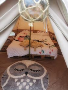 a room with a bed and a rug with a face on it at Luna Rock Glamping Brezoi - Blue Scai in Brezoi