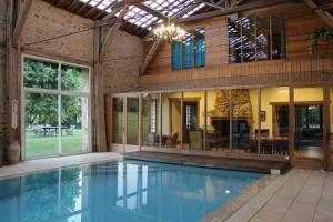 une piscine intérieure dans une maison avec un bâtiment dans l'établissement Manoir La Force avec piscine et spa, à Jumilhac-le-Grand