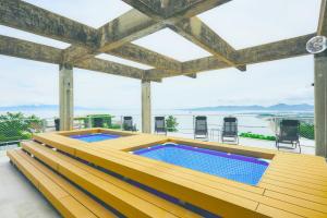 una vasca idromassaggio su una terrazza con vista sull'acqua di Dot Glamping 赤穂 ad Ako