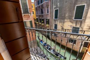 eine Gruppe von Menschen, die Motorrad entlang eines Kanals fahren in der Unterkunft Querini Suite-Balcony on canal, close to San Marco in Venedig