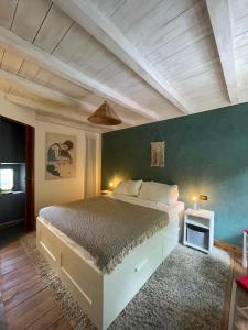 1 dormitorio con 1 cama grande y pared azul en Villa Doubledot, en Piane di Montorio