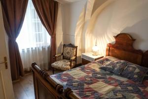 Un dormitorio con una cama, una silla y una ventana en Pont Vendégház, en Kőszeg 50 fotos más