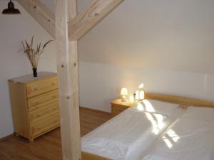 1 dormitorio con cama de madera y tocador de madera en Apartmány MarAqua, en Liptovský Trnovec