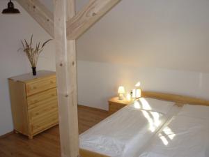 a bedroom with a wooden bed and a wooden dresser at Apartmány MarAqua in Liptovský Trnovec +24 photos