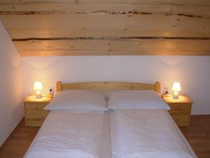 a bedroom with a bed with two lights on both sides at Apartmány MarAqua in Liptovský Trnovec