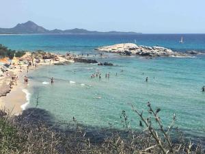 grupa ludzi w wodzie na plaży w obiekcie Casa Rosa di Maria Gabriella San Vito a 30 Km da Villasimius w mieście San Vito