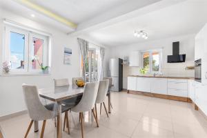 a kitchen and dining room with a table and chairs at Apartment Mariuccia with Private Pool in Vrsar