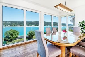a dining room with a glass table and chairs at Appartements Schwarzvilla in Velden am Wörthersee