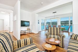 a living room with two couches and a television at Appartements Schwarzvilla in Velden am Wörthersee