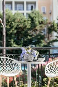 Dos sillas y una mesa con una cesta de flores. en E & G figareto apartments 5 en Kanoni
