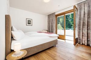 a bedroom with a bed and a large window at Appartements Schwarzvilla in Velden am Wörthersee