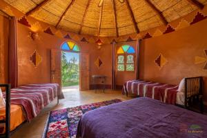 Postel nebo postele na pokoji v ubytování Ecolodge La Palmeraie