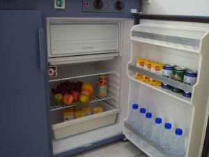 an open refrigerator filled with lots of food and drinks at Despina Studios in Agia Marina Nea Kydonias