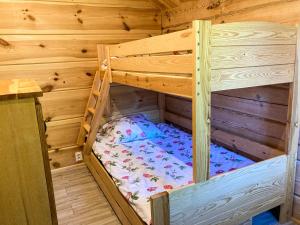 a wooden bunk bed in a wooden cabin at Domki Kaktus in Osieki