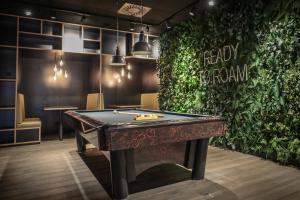 a pool table in a room with a green wall at Revier Mountain Lodge Montafon in Sankt Gallenkirch