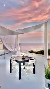 un tavolo e sedie su un balcone con vista sull'oceano di Corallini Luxury Apartments - Bokè Apartment a Cervo