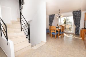 comedor y sala de estar con escaleras y mesa en Global Properties, Adosado en primera linea de playa con vistas al mar, en Sagunto