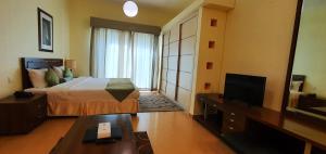 a hotel room with a bed and a television at Tulip Hotel Apartments in Dubai