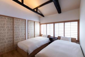 - 2 lits dans une chambre avec 2 fenêtres dans l'établissement kuon hotel kyoto shichijo, à Kyoto