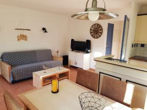 ein Wohnzimmer mit einem Sofa und einem Tisch in der Unterkunft Maison de 3 chambres avec piscine partagee terrasse amenagee et wifi a Lacanau a 2 km de la plage in Lacanau