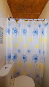 a bathroom with a toilet and a shower curtain at Calatagan's Bahay Kubo - with Beach Access in Batangas City