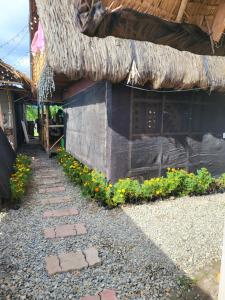 a building with a stone walkway and some flowers at Calatagan's Bahay Kubo - with Beach Access in Batangas City