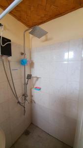 a bathroom with a shower with a shower head at Calatagan's Bahay Kubo - with Beach Access in Batangas City