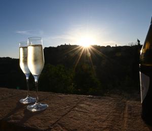 a glass of wine sitting on a table with the sunset at Stelle di Monte in Montepulciano