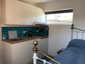 una cucina con lavandino e un letto in una camera di Flat Rocks, with parking, 100m from beach a Perranporth