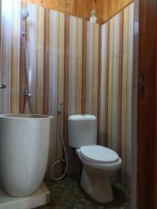 łazienka z toaletą i wanną w obiekcie Omah Kayu Villa w mieście Pasirputih