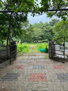 a gate in a park with a stone walkway at H Villa in Nilambūr