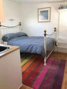 a bedroom with a bed and a rainbow rug at Flat Rocks in Perranporth