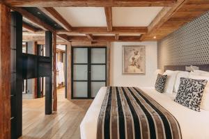 a bedroom with a large bed and wooden ceilings at Les Suites &ndash; Maison Bouvier in Tignes