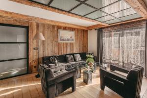 uma sala de estar com um sofá e uma mesa de vidro em Les Suites – Maison Bouvier em Tignes