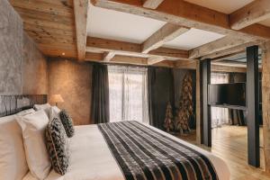 a bedroom with a large bed and a large window at Les Suites – Maison Bouvier in Tignes