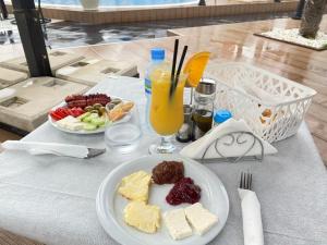 a table with a plate of food and a glass of orange juice at NOLEA Boutique Hotel in Velipojë
