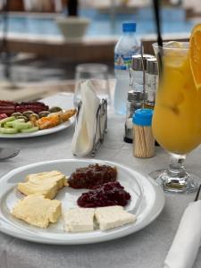 a table with two plates of cheese and a glass of orange juice at NOLEA Boutique Hotel in Velipojë