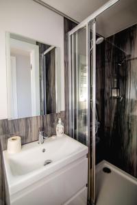 un bagno con un lavandino bianco e una doccia di Houseboat- dom na wodzie z sauną i możliwością pływania a Iława