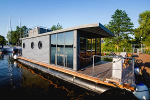 una barca è ormeggiata in acqua di Houseboat- dom na wodzie z sauną i możliwością pływania a Iława
