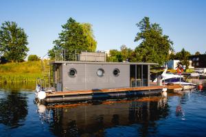 una barca è ormeggiata sull'acqua di Houseboat a Iława