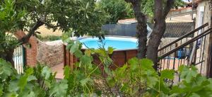 a swimming pool with a fence and a tree at Casa Quevedo in Salamanca