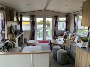 een woonkamer met een bank en een tafel bij Finch 25 - Meadow Lakes Holiday Park in St Austell