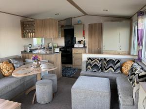 een woonkamer met een bank en een tafel in een caravan bij Finch 25 - Meadow Lakes Holiday Park in St Austell