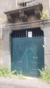 a green door in a building with a window at CASETTA ROMANTICA Tra Etna e mare in Trecastagni