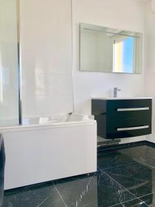 uma casa de banho com um lavatório branco e um espelho. em Apartment with Disneyland view! em Chessy