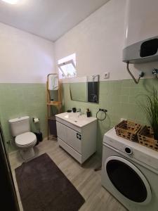 a bathroom with a toilet and a sink and a washing machine at Desertas View Apartment in Machico +37 photos