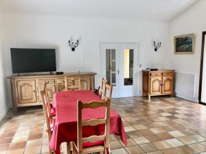 a dining room with a table and a television at Maison Nature Bretagne 3 chambres Plain-Pied in Langonnet